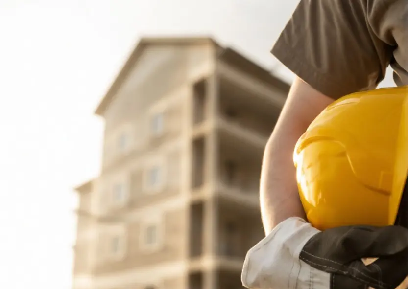 Pair of builders gloves and safety gear on a work surface